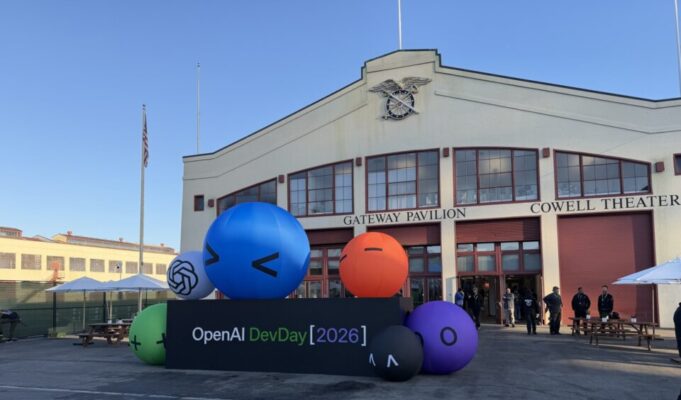 Fachada do Fort Mason, em São Francisco, com o letreiro OpenAI DevDay 2026 e esferas infláveis coloridas em frente