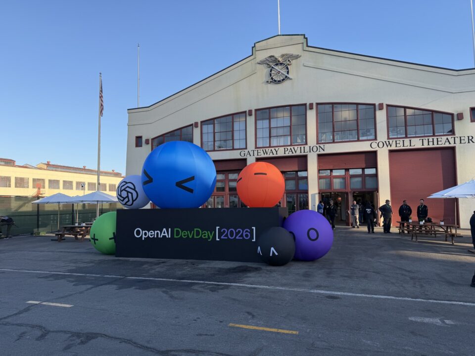 Fachada do Fort Mason, em São Francisco, com o letreiro OpenAI DevDay 2026 e esferas infláveis coloridas em frente